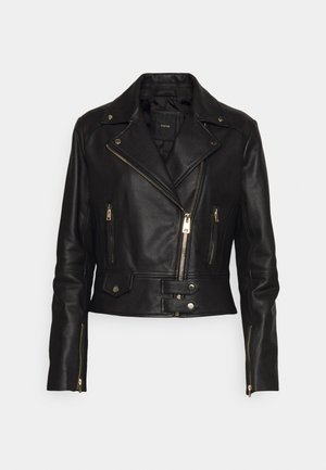 Chaqueta de moto de cuero negro con cremallera asimétrica, múltiples bolsillos con cremallera y detalles de botones a presión, con un diseño corto y textura suave.