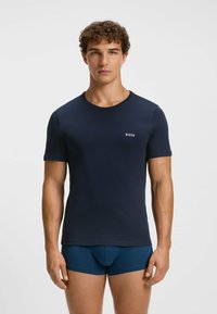 T-shirt blu navy a maniche corte realizzato in tessuto morbido, con scollatura rotonda e un piccolo logo bianco "BOSS" sul petto.