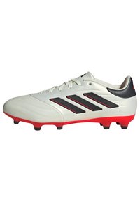Botas de fútbol blancas con acentos negros y suela roja. Presentan tres rayas negras en el lateral y una parte superior de textura suave.