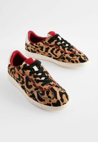 Sneaker con stampa leopardata realizzate in morbido suede testurizzato, con dettagli rossi sul colletto e nei punti di cucitura, lacci neri e una suola in gomma bianca.