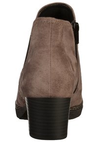 Bottine en daim marron avec un talon noir épais, équipée d'une fermeture éclair latérale et d'un détail de couture le long de la semelle.