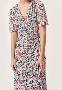Vestido envolvente con estampado floral en tejido ligero y transparente. Presenta escote en V, mangas cortas abullonadas y una variedad de flores rojas, azules y beige.