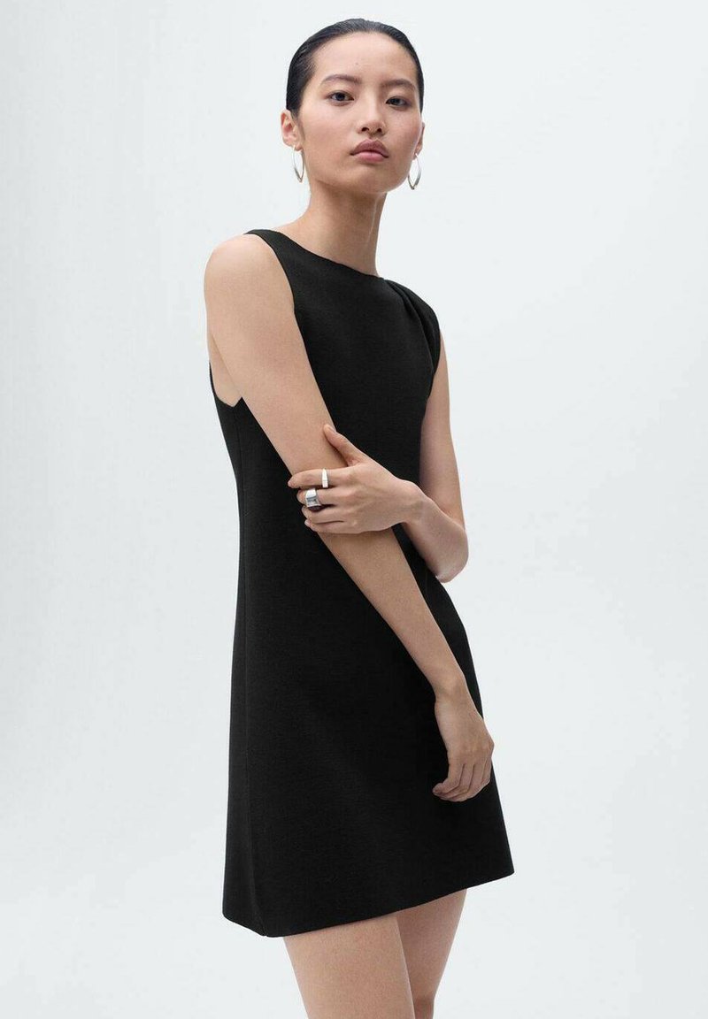 Black sleeveless dress with a fitted design, featuring a boat neckline and smooth texture, worn by a model with accessories.