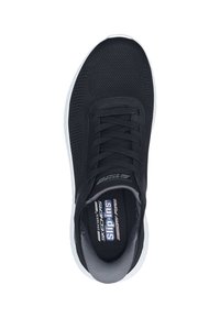 Scarpa sportiva nera in rete con parte superiore testurizzata, suola bianca e lacci piatti. Presenta una fodera grigia e il marchio Skechers sulla soletta.