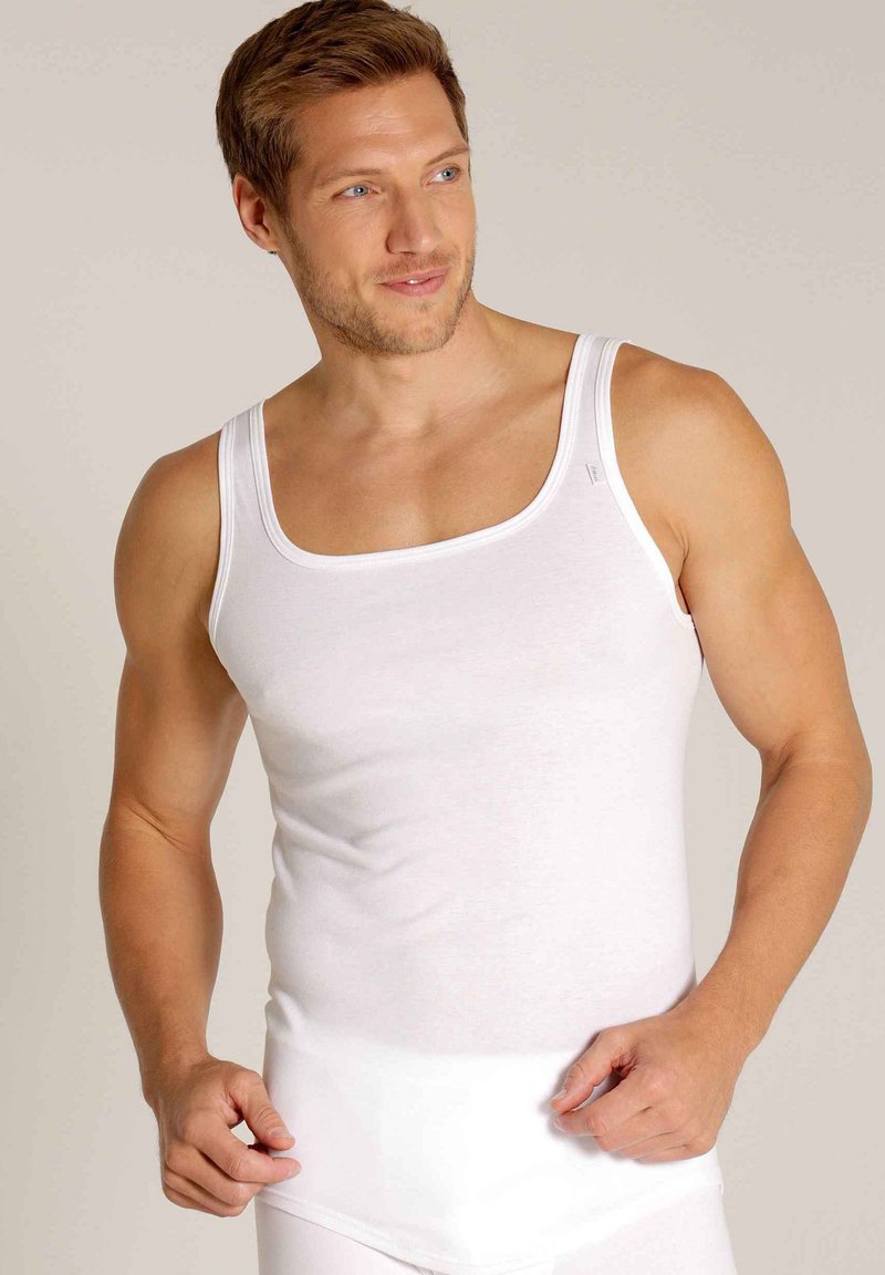 White tank top, made of soft cotton. Features a square neckline, wide straps, and a smooth texture. Simple design, no visible patterns or accents.