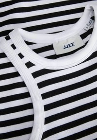 Čierno-biely pruhovaný bavlnený shirt s okrúhlym ribovým výstrihom a štítkom na starostlivosť, ktorý obsahuje rovnomerné horizontálne pruhy rôznej hrúbky.