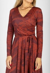 Sukienka kopertowa z długim rękawem, wykonana z teksturowanej, elastycznej tkaniny. Bogaty burgundowy kolor z botanicznym wzorem i ozdobnym wiązaniem w talii.