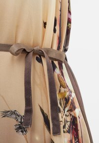 Lehký béžový župan s květinovým vzorem. Má hnědý pás a jemnou texturu, doplněný ilustracemi ptáků.