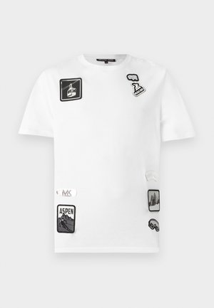 Maglietta bianca in cotone a maniche corte, con varie toppe nere e grigie tra cui "Aspen" e disegni di montagne, con accenti di logo.