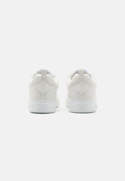 Zapatillas blancas con un upper de cuero suave, un collar acolchado en el tobillo, acentos texturizados y una suela de goma con un patrón geométrico.