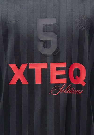 Μαύρη και σκοτεινή γκρι ριγέ αθλητική φανέλα με αριθμό 5 στο κέντρο, κόκκινο λογότυπο "XTEQ Solutions" από κάτω και διακριτικό κείμενο "HAN KJØBENHAVN" στο αριστερό στήθος.