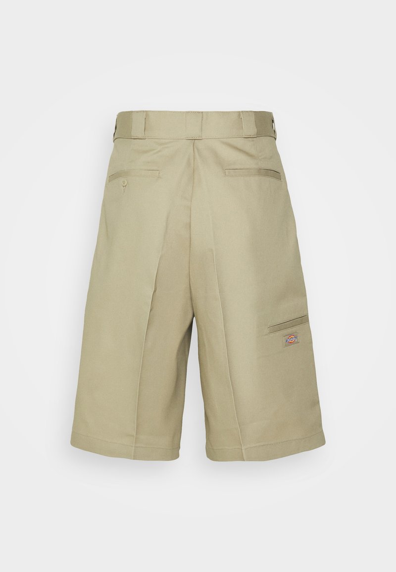 Beige cargo shorts made of sturdy fabric, featuring side and back pockets, pleated design, and a small logo on the left pocket.