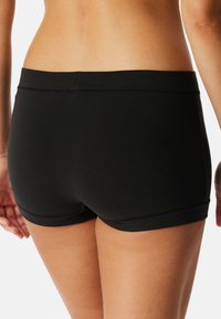 Svarta shorts i bomullsblandning med en slät textur, utrustade med en figurnära design och vändsydd nederkant, som visar en sömlös midja.