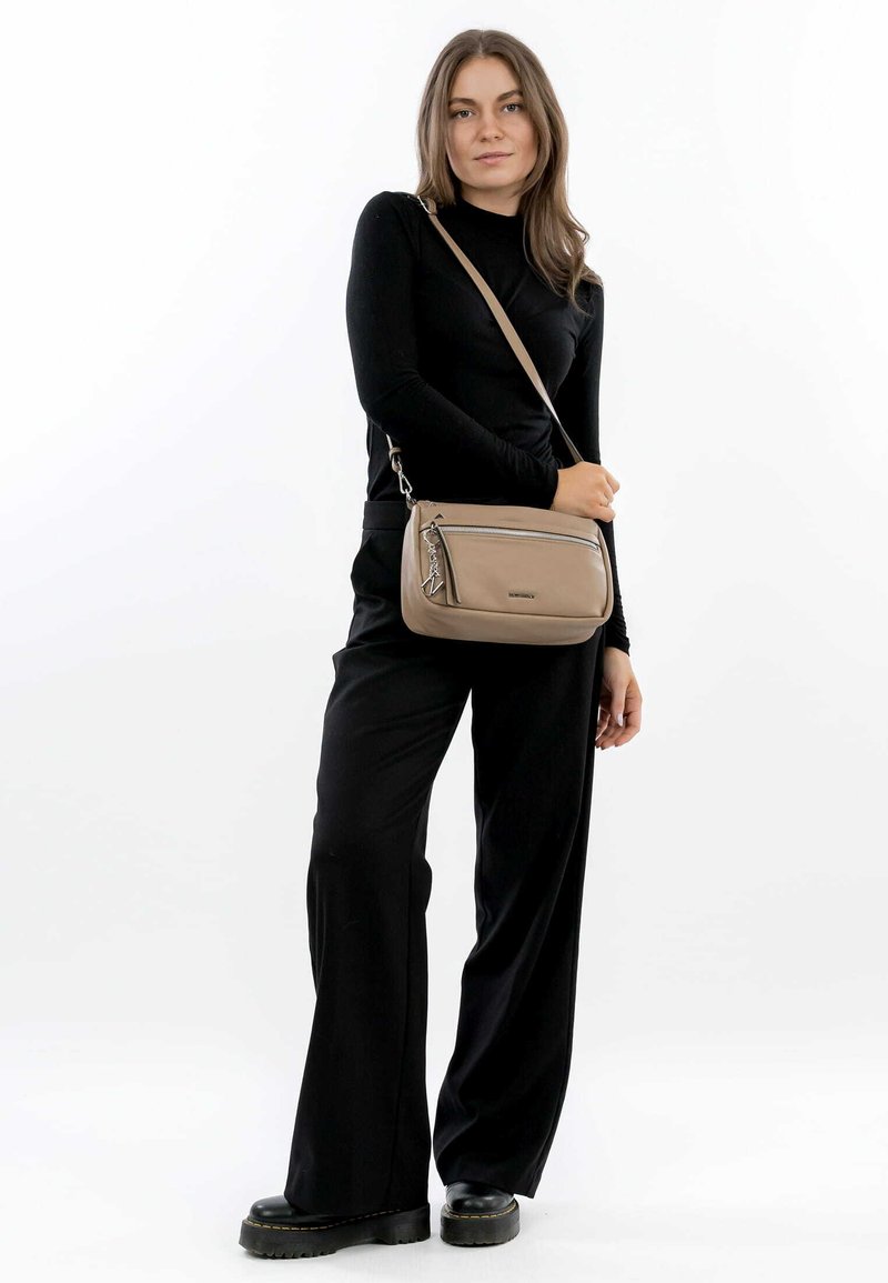 Borsa a tracolla marrone chiaro con tasca con zip e tracolla a catena. Texture liscia con design minimalista e dettagli accentuati. Leggera e compatta.