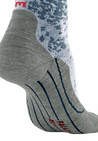 Socken mit mehreren Mustern, grauem Fersen- und Zehenbereich, weißem Oberteil mit blauen Designs und geripptem Textur entlang des Fußbetts. Rotes Logodetail.