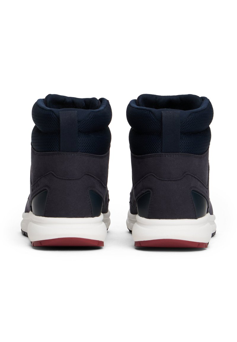 Dark blue high-top sneakers feature a suede upper with mesh detailing, a padded collar, and a white midsole with a red accent on the outsole.