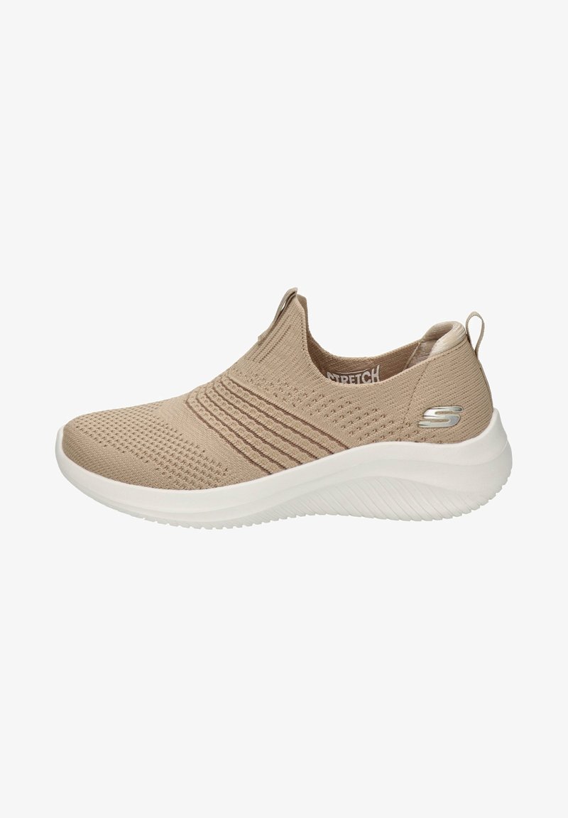Zapato slip-on de punto beige con parte superior texturizada, collar elástico y suela de goma blanca. Presenta un pequeño logo metálico en el costado.