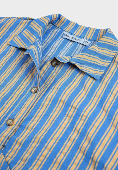Chemise pour enfants rayée bleu et jaune, taille 6-7 ans, avec col et étiquette de marque "BOBO CHOSES" à l'intérieur.
