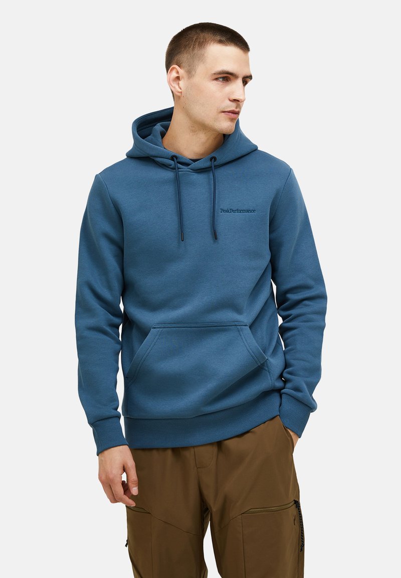 Blaues Sweatshirt mit Kordelzug, Vordertasche und gerippten Bündchen. Mit "PeakPerformance"-Logo auf der Brust in schwarzer Stickerei.