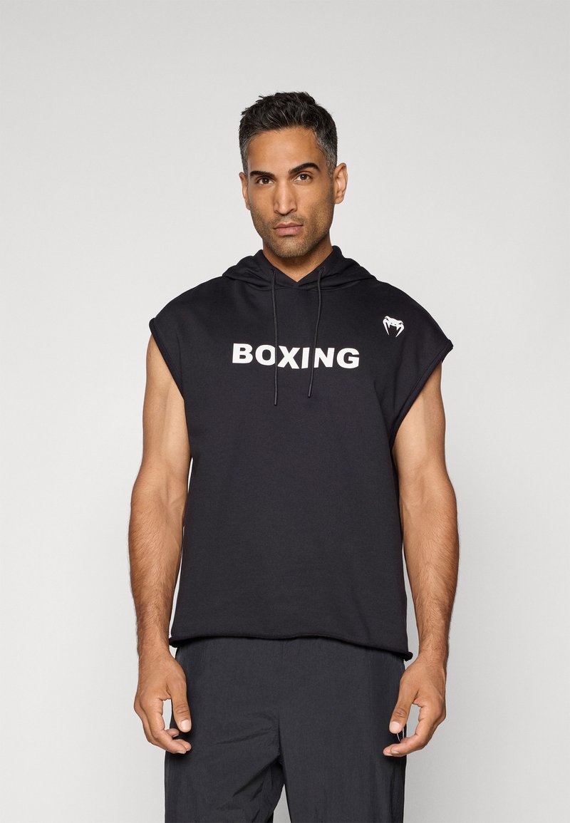 Svart, ermeløs hettegenser med snor, hvit "BOXING" tekst og liten logo på skulderen. Mykt stoff og avslappet passform.