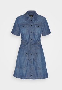 Jeansskjortklänning med korta ärmar, knäppning fram, två bröstfickor, ett knytbälte i midjan och en något utsvängt nederkant.