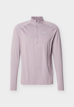 Haut de sport Nike à manches longues de couleur violet clair, avec une fermeture éclair quart et un col haut, comportant un petit logo Nike swoosh blanc sur la poitrine.