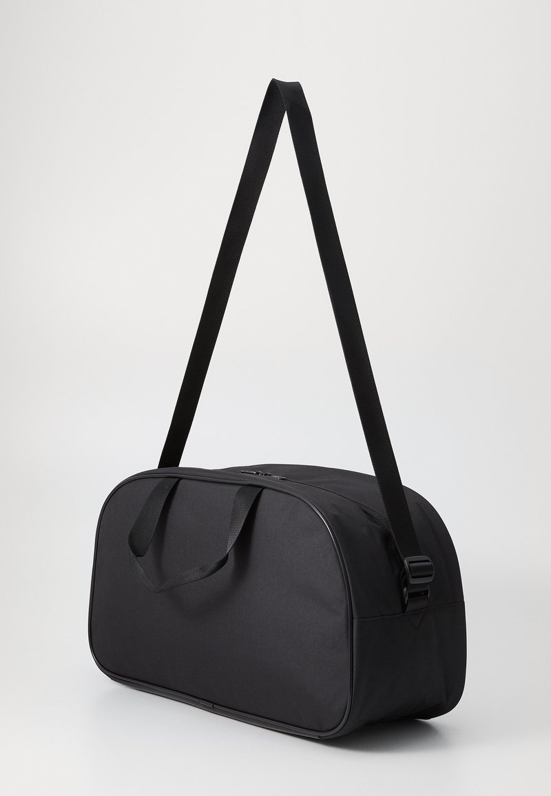Borsa a duffle nera con forma arrotondata, materiale in tessuto, doppie maniglie e una tracolla regolabile. Presenta una chiusura con zip e nessun motivo visibile.
