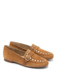 Brown suede loafers with rounded toes, featuring a strap with a silver buckle and decorative silver studs along the upper. Flat sole.