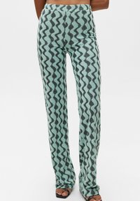 Light blue patterned pants with a wavy dark gray design. They are fitted at the waist, with a flared leg and soft, textured fabric.