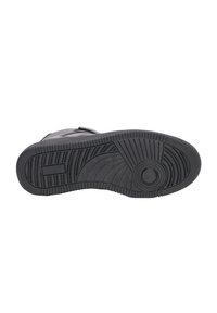 Suela de zapato de goma negra con surcos texturizados, patrones circulares y rectangulares, y un detalle central circular para la tracción.