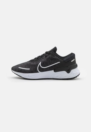 Schwarzer und grauer Nike Laufschuh mit weißer Sohle und weißem Swoosh-Logo, seitlich auf hellem einfarbigen Hintergrund gezeigt.
