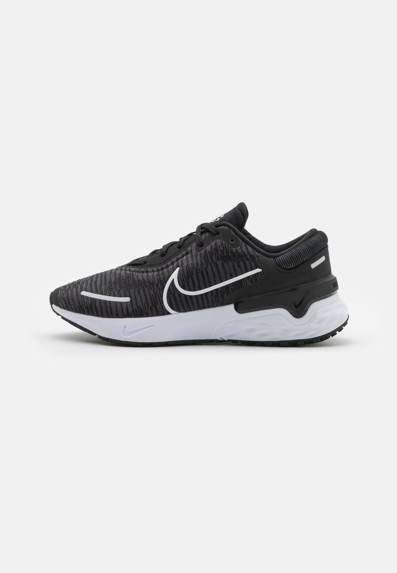 Chaussure de course Nike noire et grise avec semelle blanche et logo swoosh blanc, vue de côté sur fond clair uni.
