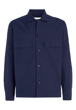 Camicia button-up blu realizzata in tessuto leggero, con due tasche sul petto, un colletto classico e maniche lunghe. I bottoni sono rotondi.
