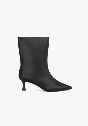 Bottines noires en cuir lisse, avec un bout pointu et un talon bas élancé. Design minimaliste sans quincaillerie ni accents visibles.