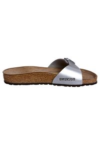 Sandalo scivoloso in pelle argentata con soletta in sughero, fibbia regolabile e suola testurizzata. Nome del marchio "Birkenstock" stampato di lato.