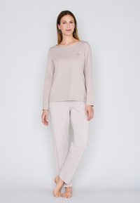 Jasnoróżowa bluzka z długim rękawem i dekoltem typu łódka; wzorzyste piżamowe spodnie w jasnoróżowym kolorze z białymi serduszkami; miękki, komfortowy materiał; luźny krój.