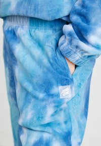 Fleece joggers i gradientfarger av blått, med elastisk midjebånd og en sidelomme, med et lite hvitt logo-patch.
