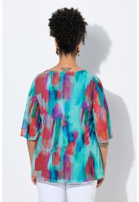 Top multicolore a maniche corte con una miscela di acquerelli blu, rossi e viola in una struttura setosa. Collo rotondo, vestibilità ampia.