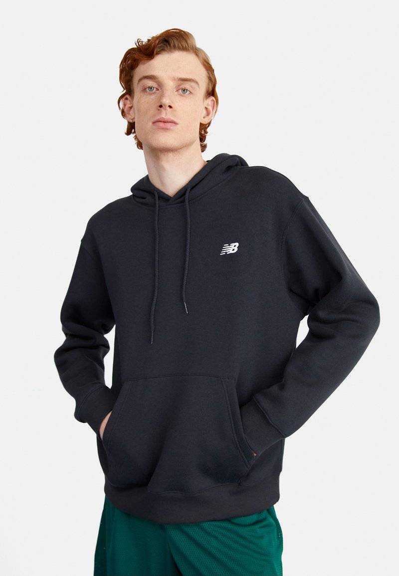 Hoodie noir avec cordon de serrage, doté d'une poche frontale et d'un logo blanc sur la gauche de la poitrine. Texture lisse, design décontracté.
