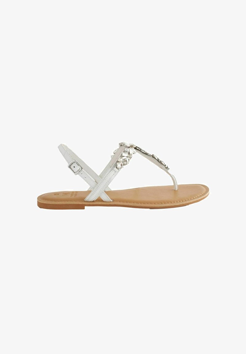 Witte platte sandalen met een teenslipperontwerp, voorzien van decoratieve kralen, een verstelbare enkelband en een gladde tan-kleurige binnenzool.