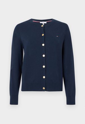 Cardigan bleu marine à manches longues avec col rond et boutons dorés sur le devant, avec un petit logo Tommy Hilfiger sur la poitrine.
