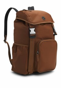 Brązowy plecak z nylonu z klapą, regulowanymi czarnymi paskami, przednią kieszenią na zamek i akcentami sprzętu z logo. Szczotkowane detale paska.