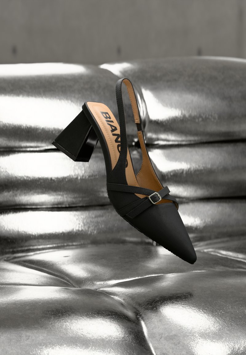 Μαύρο παπούτσι slingback με μυτερή μύτη και φαρδειά τακούνι μπλοκ, με λεπτομέρεια διακριτικής αγκράφας και απαλό υφασμάτινο ύφασμα.