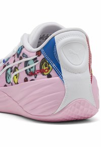 Többszínű sportcipő, pink alappal, játékos grafikákkal, fehér bőr kiegészítőkkel és texturált rózsaszín talppal a tapadás érdekében.