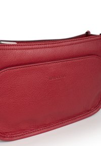 Borsa in pelle rossa con superficie testurizzata, dotata di chiusura a zip e logo impresso in rilievo. Design sottile con forma piatta e stile minimalista.