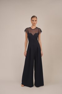 Mørkeblå jumpsuit med tettsittende liv med hjertesmykkekant og gjennomsiktige korte ermer, kombinert med vide bukser.