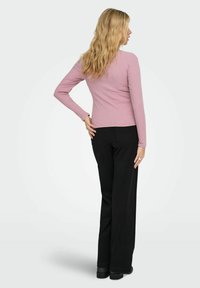 Jasnofioletowa, prążkowana bluzka z długim rękawem połączona z wysokimi, czarnymi spodniami o szerokiej nogawce. Strój charakteryzuje się prostym wzornictwem i miękką fakturą.