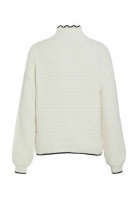 Bílý pletený svetr s ribovanou texturou, vysokým límcem a vlnitými okraji, s horizontálními pruhy a černými akcenty na spodním lemu a na manžetách.