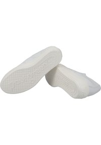 Zapatillas blancas con parte superior de cuero liso, suela de goma texturizada y diseño minimalista. Incluye perforaciones para mayor transpirabilidad.