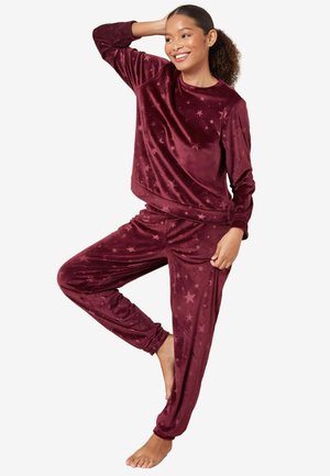 Burgunderfarbene Velours-Loungewear mit einem langärmeligen Oberteil im Sternenmuster und passenden taillierten Hosen mit elastischen Bündchen und Taillenbund.